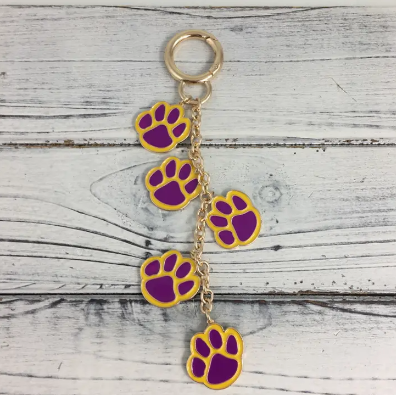 Purple and gold paw print bag or purse charm accessory for gameday and tailgating for LSU sports fans.